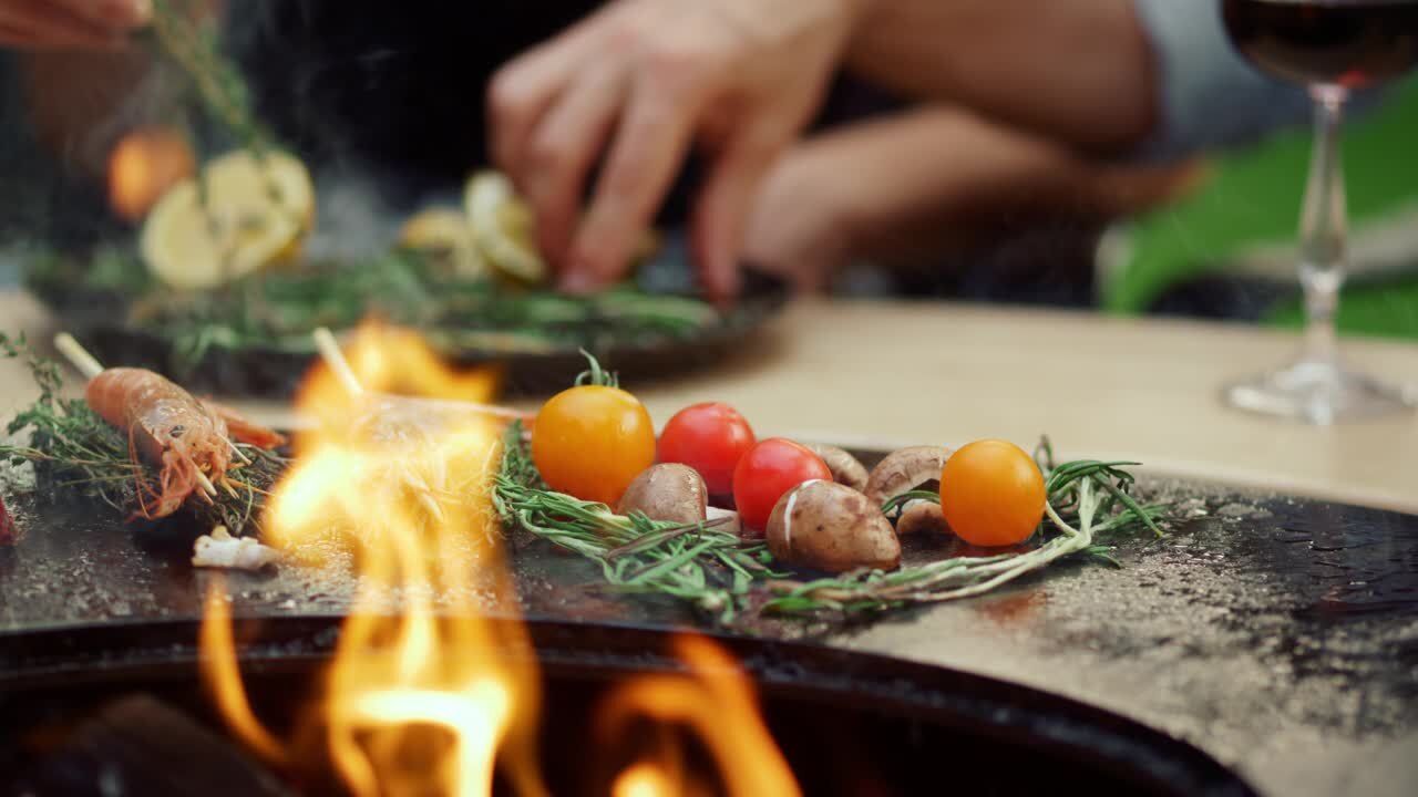 Offene Flamme mit Gemüse und Kräutern auf der Feuerstelle